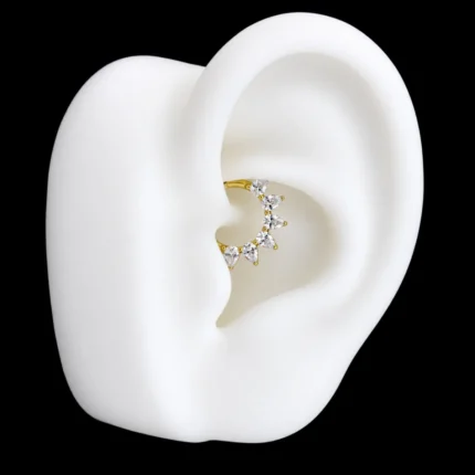 Aro clicker dorado con circones gota puesto en piercing daith