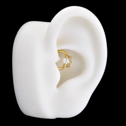 Aro clicker Janet Van Dyne dorado con mariposa puesto en el daith de una oreja de maqueta