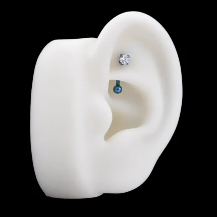 Barra curva azul con circón blanco puesta en piercing rook