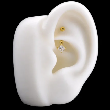 Barra curva dorada con circón cuadrado puesta en piercing rook de oreja