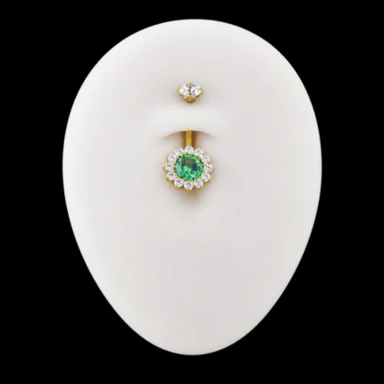 Piercing de ombligo Peonías dorado con circón verde puesto en maqueta de abdomen