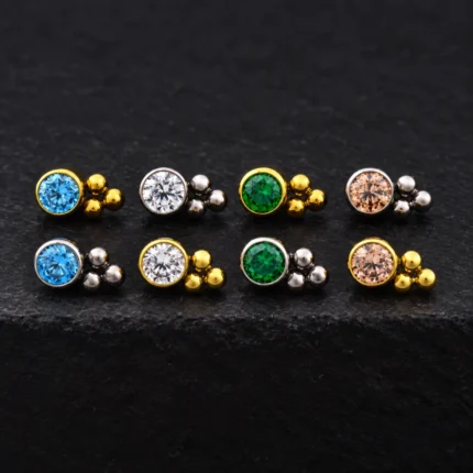 Tops de titanio dorado y plateado con circón redondo en bisel y tres bolitas, en azul, blanco, verde y champaña
