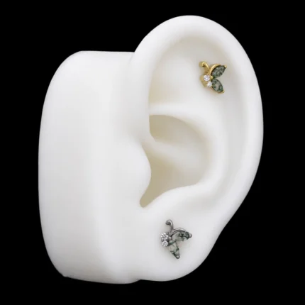 Tops mariposa de ágata musgo puestos en hélix y lóbulo de una maqueta de oreja
