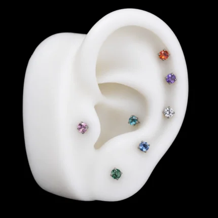 Labrets de circones de colores puestos en hélix, conch, tragus y lóbulo de una maqueta
