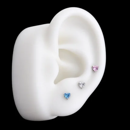 Tops corazón de circón rosado, blanco y azul puestos en el lóbulo