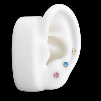 Tops de circón cuadrado rosado, azul y blanco puestos en el lóbulo